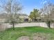 Fenced backyard with a well-maintained lawn and mature trees at 6974 Trellis Vine Loop, Windermere, FL 34786