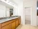 Double vanity bathroom with tan floors, wood cabinets, granite counters and a large mirror at 6974 Trellis Vine Loop, Windermere, FL 34786
