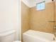 Bright bathroom with tiled walls around the tub and a small window above at 6974 Trellis Vine Loop, Windermere, FL 34786