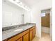 Bright bathroom with a double sink vanity, granite counters, and large mirror. A separate bath is also visible at 6974 Trellis Vine Loop, Windermere, FL 34786
