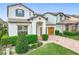 Two-story home featuring a paver driveway, two-car garage, manicured lawn, and green landscaping at 6974 Trellis Vine Loop, Windermere, FL 34786
