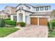 A beautiful two-story home with a paver driveway, two-car garage, manicured lawn, and beautiful landscaping at 6974 Trellis Vine Loop, Windermere, FL 34786