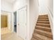 Hallway with tile flooring leads to a bathroom and carpeted stairs at 6974 Trellis Vine Loop, Windermere, FL 34786
