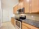 This kitchen features stainless steel appliances, granite countertops and wood cabinets at 6974 Trellis Vine Loop, Windermere, FL 34786