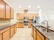 Bright kitchen with stainless appliances, granite counters, island with sink, and tile floors at 6974 Trellis Vine Loop, Windermere, FL 34786