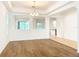 Living room with modern floors, large windows, chandelier, and kitchen view at 6974 Trellis Vine Loop, Windermere, FL 34786