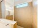 Tiled shower with tan tiling behind a glass door and a window at 6974 Trellis Vine Loop, Windermere, FL 34786