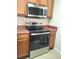 This kitchen has an oven, a microwave, and wood cabinets at 8137 Claire Ann Dr # 203, Orlando, FL 32825