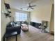 Spacious living room featuring contemporary furnishings, overhead fan, and large window at 8137 Claire Ann Dr # 203, Orlando, FL 32825