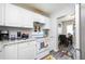 Bright kitchen with white cabinets, gray laminate flooring and granite countertops at 1006 San Domingo Rd, Orlando, FL 32808