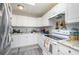 Bright kitchen with white cabinets, gray laminate flooring and granite countertops and stainless steel refrigerator at 1006 San Domingo Rd, Orlando, FL 32808
