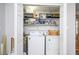 Convenient laundry closet featuring a washer, dryer, and built-in shelving for storage at 1006 San Domingo Rd, Orlando, FL 32808