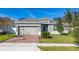 Charming single-Gathering home featuring a well-maintained lawn, brick driveway, and two-car garage at 1097 Hendon Loop, Davenport, FL 33837