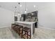Modern kitchen with dark cabinetry, stainless steel appliances, and a spacious island with seating at 1097 Hendon Loop, Davenport, FL 33837