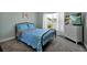 Bedroom features a bed with blue patterned bedding, a dresser with a TV, and a sunlit window at 1238 James Ln, Kissimmee, FL 34759