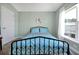 Bedroom with a black metal bed frame, blue bedding, and a window that provides natural light at 1238 James Ln, Kissimmee, FL 34759