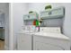 Bright laundry room featuring a washer, dryer, overhead cabinets, and modern decor at 1238 James Ln, Kissimmee, FL 34759