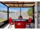 Enclosed patio with a glass top table and four red chairs overlooking the backyard at 1238 James Ln, Kissimmee, FL 34759