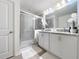 Bathroom featuring a glass-enclosed shower, granite countertop, and dual sinks at 1524 Venice Ln, Davenport, FL 33896