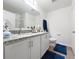 Bathroom with granite countertop, white cabinets, and a large mirror at 1524 Venice Ln, Davenport, FL 33896