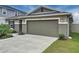 Exterior view of a home with a spacious two-car garage and a well-kept lawn at 1524 Venice Ln, Davenport, FL 33896