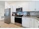 Modern kitchen featuring stainless steel appliances, white cabinets, and granite countertops at 1524 Venice Ln, Davenport, FL 33896