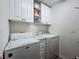 Bright laundry room featuring a side-by-side washer and dryer and white cabinets at 1524 Venice Ln, Davenport, FL 33896
