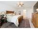 Cozy main bedroom featuring a wood bed frame, ceiling fan, and a view into the ensuite bathroom at 1524 Venice Ln, Davenport, FL 33896
