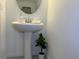 Stylish pedestal sink in a minimalist bathroom with modern fixtures and neutral tones at 1613 Pelican Dr, Davenport, FL 33896