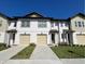 Charming two-story townhome boasts a two-car garage, well-kept lawn, and modern design at 1613 Pelican Dr, Davenport, FL 33896