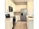 Well-equipped kitchen with white cabinets, stainless steel appliances, and a large sink at 1613 Pelican Dr, Davenport, FL 33896