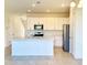 Bright kitchen with large island, white cabinets and stainless steel appliances at 1613 Pelican Dr, Davenport, FL 33896