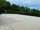 Community sand volleyball court surrounded by lush landscaping and mature trees at 1613 Pelican Dr, Davenport, FL 33896