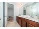 A bright bathroom featuring double sinks, a large mirror, and access to a private toilet and shower area at 1737 Caribbean View Ter, Kissimmee, FL 34747