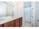 Bright bathroom featuring a vanity with wood cabinets, a large mirror, and a separate toilet area at 1737 Caribbean View Ter, Kissimmee, FL 34747