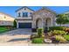 Beautiful two-story home with stone accents, arched entryway, and a well-manicured front yard at 1737 Caribbean View Ter, Kissimmee, FL 34747
