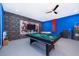 A spacious game room complete with a pool table, foosball, and a unique comic-themed design, perfect for entertainment at 1737 Caribbean View Ter, Kissimmee, FL 34747