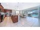 Open kitchen featuring dark wood cabinetry, granite countertops, stainless appliances, and dining area overlooking the pool at 1737 Caribbean View Ter, Kissimmee, FL 34747