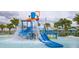 Community splash pad featuring a blue waterslide, palm trees, and sun loungers at 1737 Caribbean View Ter, Kissimmee, FL 34747