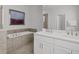Bright bathroom features double sinks, a soaking tub, and a separate glass-enclosed shower with tile surround at 194 Golden Noble St, Davenport, FL 33897
