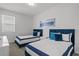 Bright bedroom featuring two twin beds with navy accents and a window for natural light at 194 Golden Noble St, Davenport, FL 33897