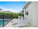Outdoor pool area with three lounge chairs, grill, and privacy landscaping provides a relaxing backyard retreat at 194 Golden Noble St, Davenport, FL 33897