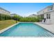Sparkling in-ground pool with lounge chairs and grill, surrounded by lush landscaping and privacy fence at 194 Golden Noble St, Davenport, FL 33897