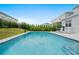 Inviting in-ground pool is surrounded by privacy landscaping, lounge chairs, and a barbecue grill at 194 Golden Noble St, Davenport, FL 33897
