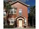 Charming two-story townhome with a welcoming front entrance and lush tropical landscaping at 19934 Villa Isle # 107, Orlando, FL 32821
