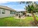 Large backyard featuring a covered patio, swing set, and banana trees at 2559 Eagle Bay Blvd, Kissimmee, FL 34743