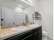 Bathroom featuring a double sink vanity with dark wood cabinets, light walls, a shelf, and a toilet at 2559 Eagle Bay Blvd, Kissimmee, FL 34743
