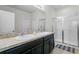 Bright bathroom featuring a double vanity with granite countertop and a tiled walk-in shower with glass door at 2559 Eagle Bay Blvd, Kissimmee, FL 34743