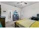 Neutral toned bedroom with a yellow patterned bedspread, TV on shelving, and connected bathroom at 2559 Eagle Bay Blvd, Kissimmee, FL 34743
