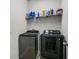 Laundry room with a side-by-side black washer and dryer with light gray walls at 2559 Eagle Bay Blvd, Kissimmee, FL 34743